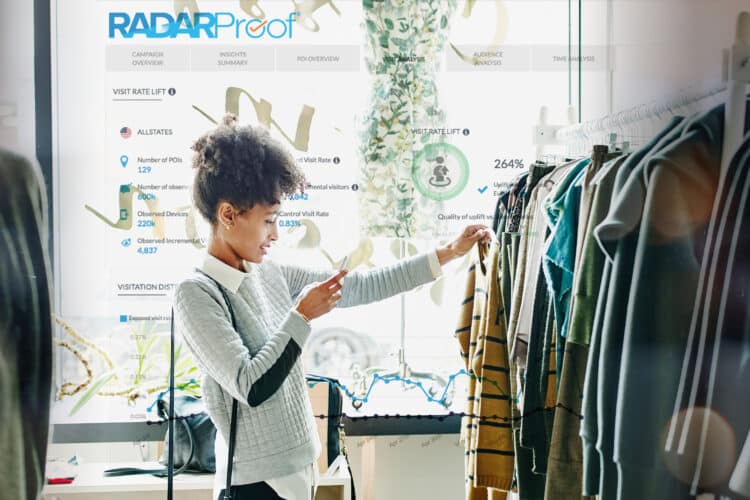 woman in store shopping for garments and sharing the image and info on her cellphone