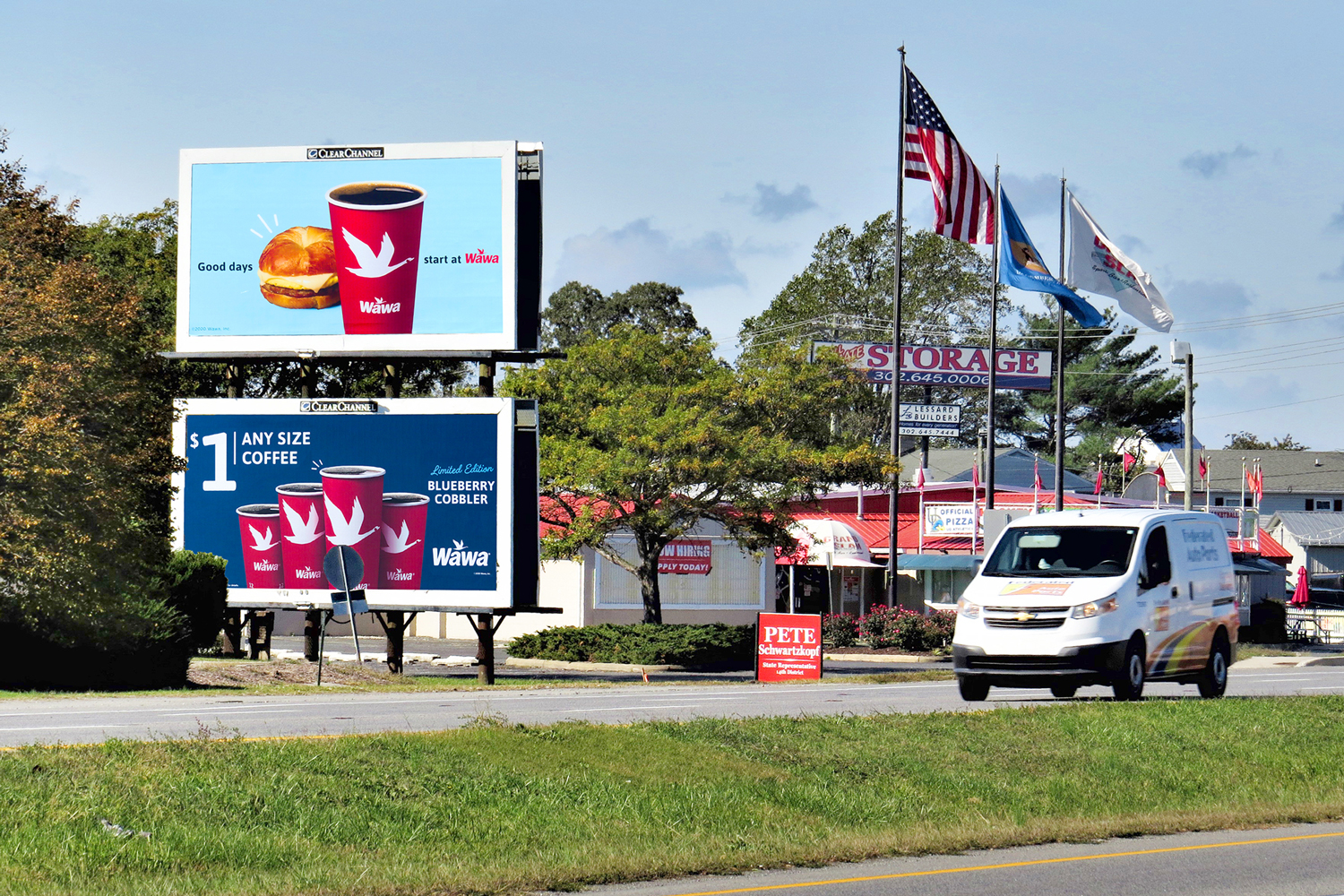 Two posters stacked on top of each other on the side of the highway. Billboard ads for Wawa coffee