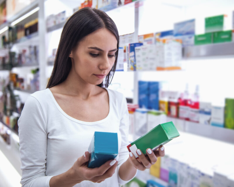 Woman is choosing a medication at the pharmacy